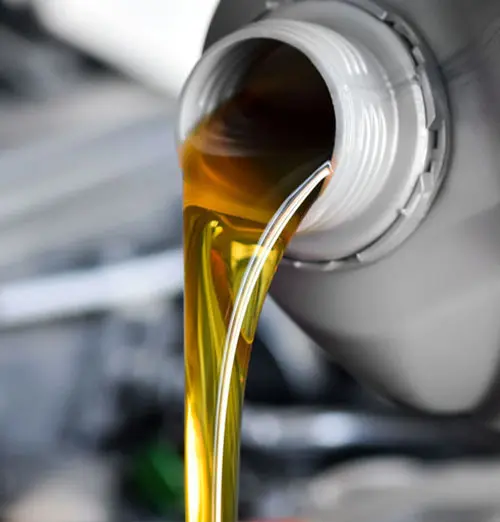 Motor oil pouring into engine