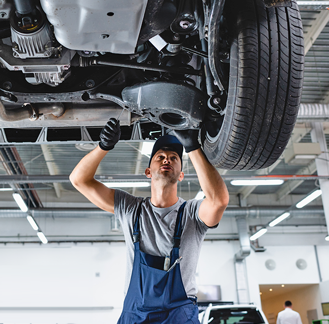 Mechanic inspecting car underside